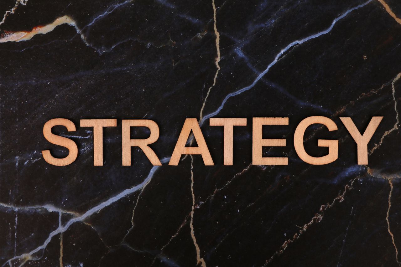 Strategic planning concept with 'Strategy' in wooden letters on dark marble.